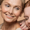 Drie vrouwen met een stralende, gehydrateerde huid als symbool voor de behandeling van een vochtarme huid.