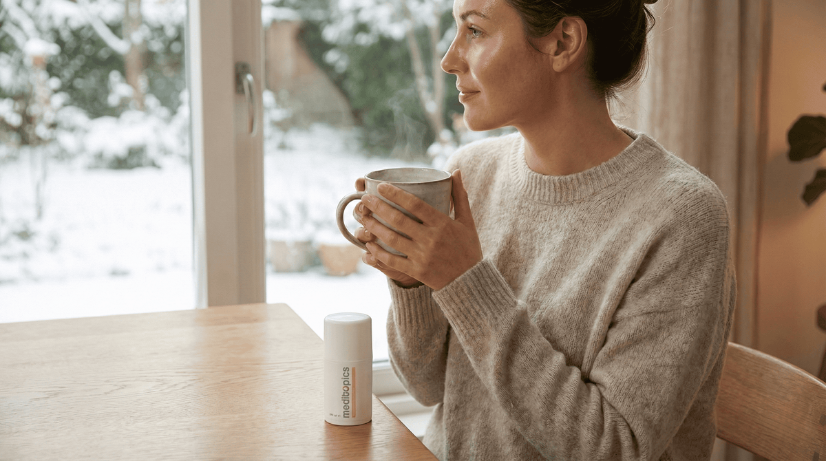 Vrouw met gezonde huid bij winterraam met Meditopics Regenererende Crème voor herstel van de huidbarrière